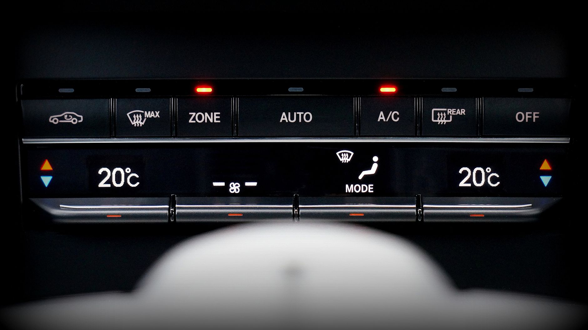 Close-up image of a car's climate control panel with digital temperature display.