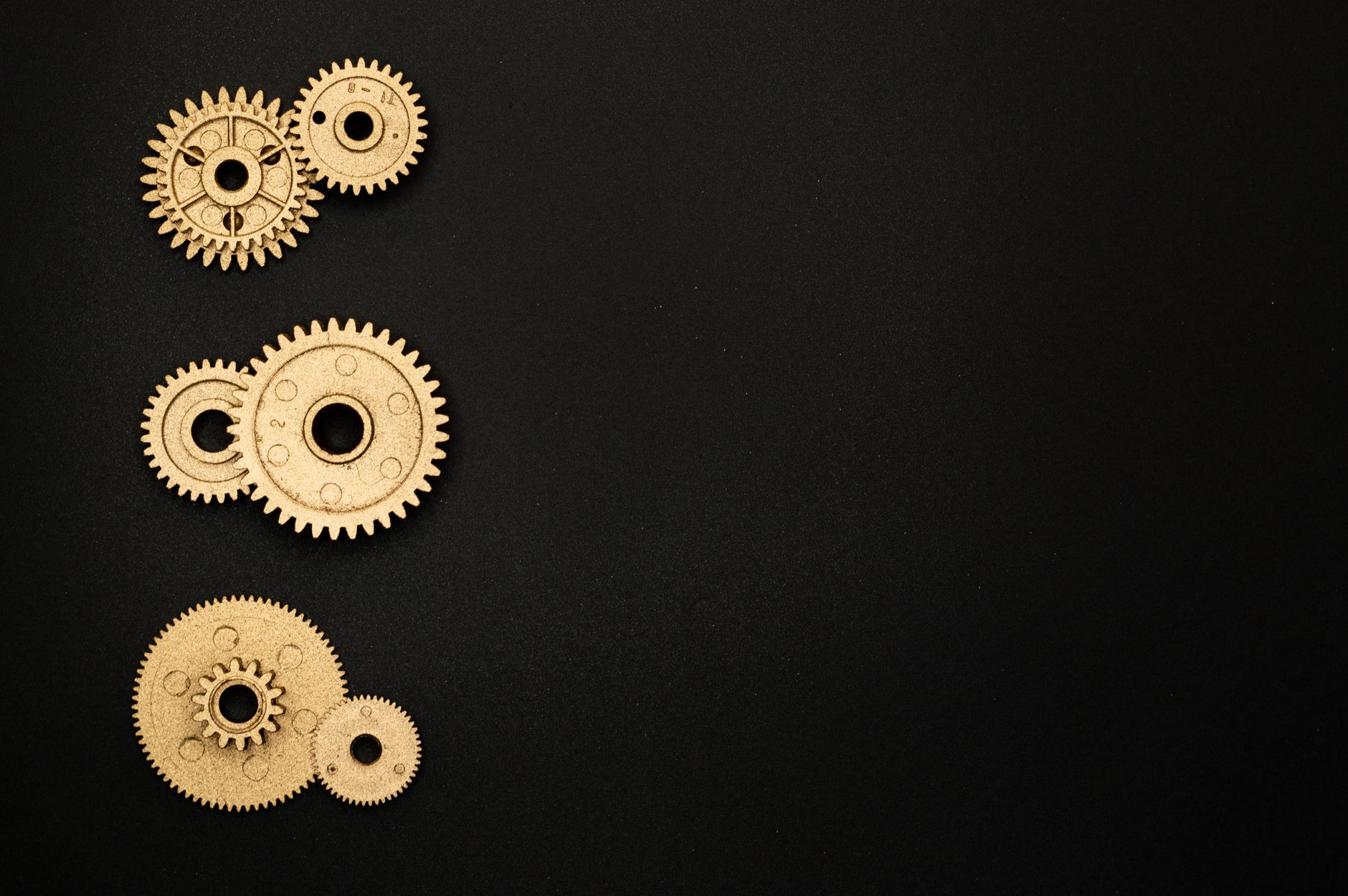 Detailed view of intricate golden gears on a sleek black background, showcasing mechanical engineering.